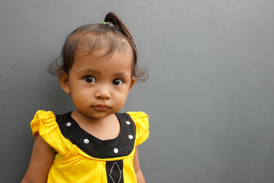 Portrait of cute baby boy standing against wall