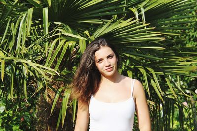 Beautiful young woman standing against plants