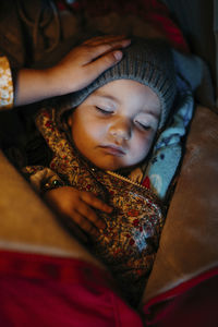 Sister admiring baby girl with warm clothing while sleeping during winter