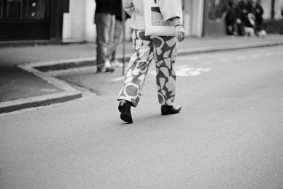 Low section of woman walking on street