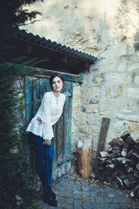 Beautiful young woman in a white lace blouse and jeans near the farmer house,  countryside