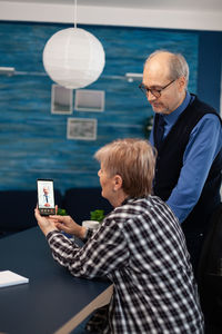 Side view of man using mobile phone while sitting at airport