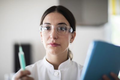 Scientist female with lab glasses, tablet and sample in a lab