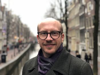 Portrait of smiling bald man standing in city