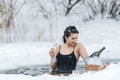 Portrait of young woman standing in snow