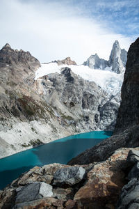 Scenic view of snowcapped mountains and glacier against cloudy sky