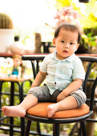 Portrait of cute boy sitting on seat