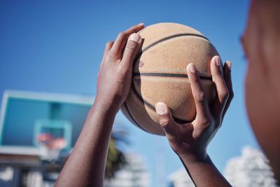 Cropped hand of man holding basketball