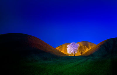 Scenic view of hills against clear blue sky at night