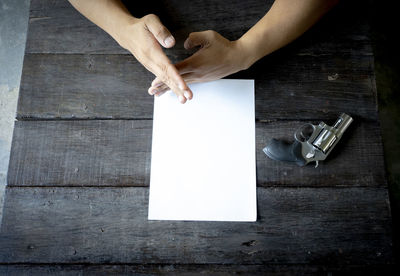 High angle view of man holding hands on table