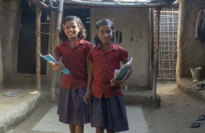 Portrait of a smiling young girl students going to school holding books