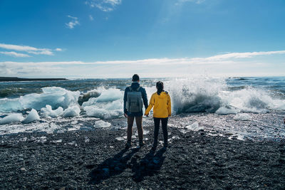 Rear view of women standing on beach