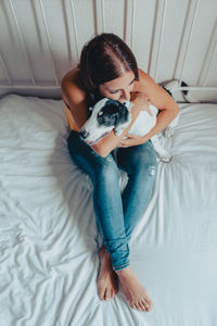 High angle view of woman with dog on bed at home