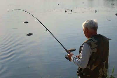 Rear view of man fishing rod