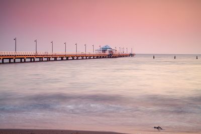 Pier over sea against sky during sunset