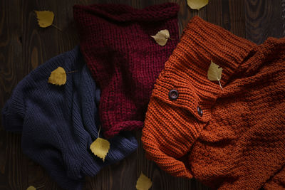 Knitted scarves on a wooden background, the concept of autumn and warm clothes