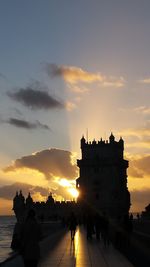 Torre de belem against sky during sunset in city