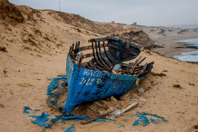 Deck chairs on beach against sky