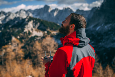 Man holding remote control against mountains