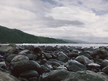 Surface level of pebble beach against sky