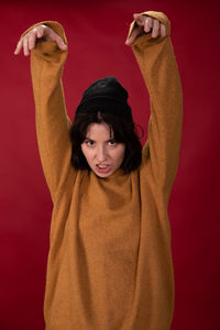 Portrait of woman standing against red background