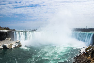 Scenic view of waterfall against sky