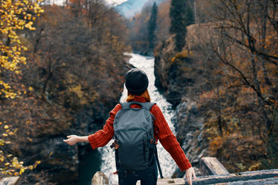 Rear view of man standing in forest during autumn