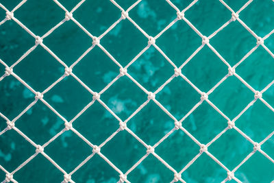 Full frame shot of swimming pool seen through chainlink fence