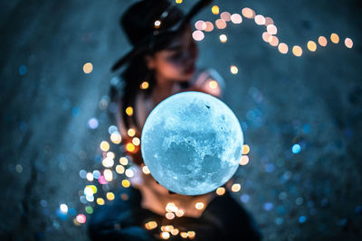 Close-up of woman with christmas lights