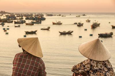 Unidentified vietnamese women overlooking fishermans bay full of fishing boats.