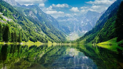 Scenic view of lake and mountains against sky