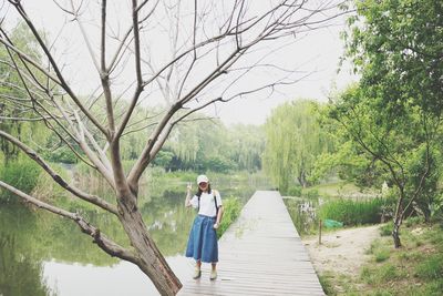 Woman standing by plants in forest