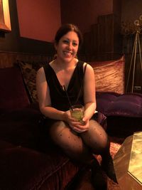 Portrait of a smiling young woman sitting at home