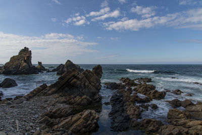 Rock formation on beach against sky