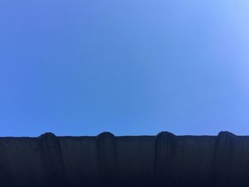 Low angle view of mountain against blue sky