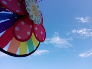 Low angle view of multi colored balloons against sky