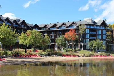 Buildings by lake against sky