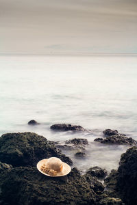 Scenic view of rocks on beach against sky