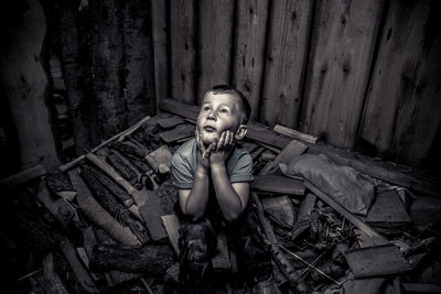 High angle view of trapped boy sitting on rubble in room