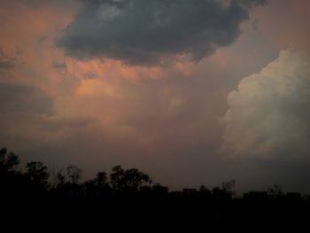 Silhouette of trees against cloudy sky