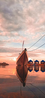 Nautical vessel by sea against sky during sunset