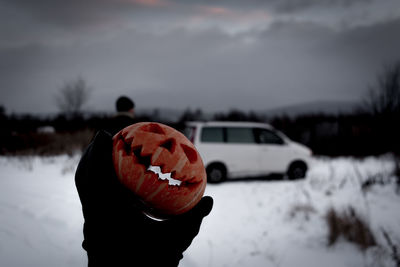 Hand holding pumpkin lantern
