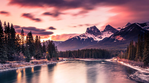 Scenic view of lake by mountains against sky during sunset
