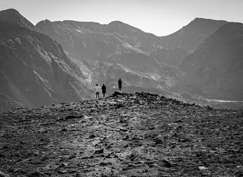 People looking at landscape while standing on mountain