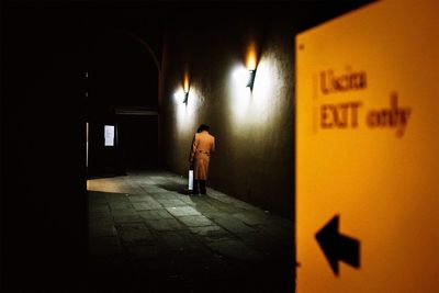 Rear view of silhouette woman walking in illuminated building