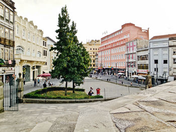 Street by buildings against sky in city