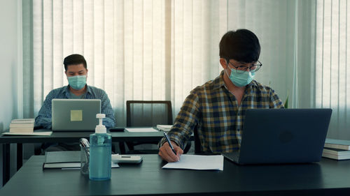 Businessmen wearing mask working in office