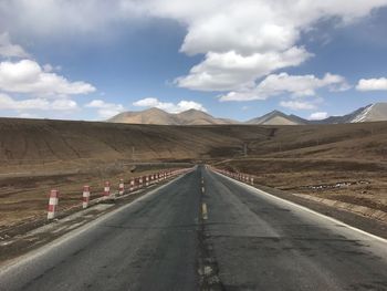 Empty road along landscape against sky