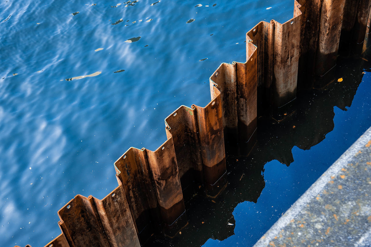 HIGH ANGLE VIEW OF WOODEN POSTS ON SEA