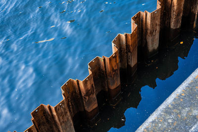 High angle view of wooden posts in sea